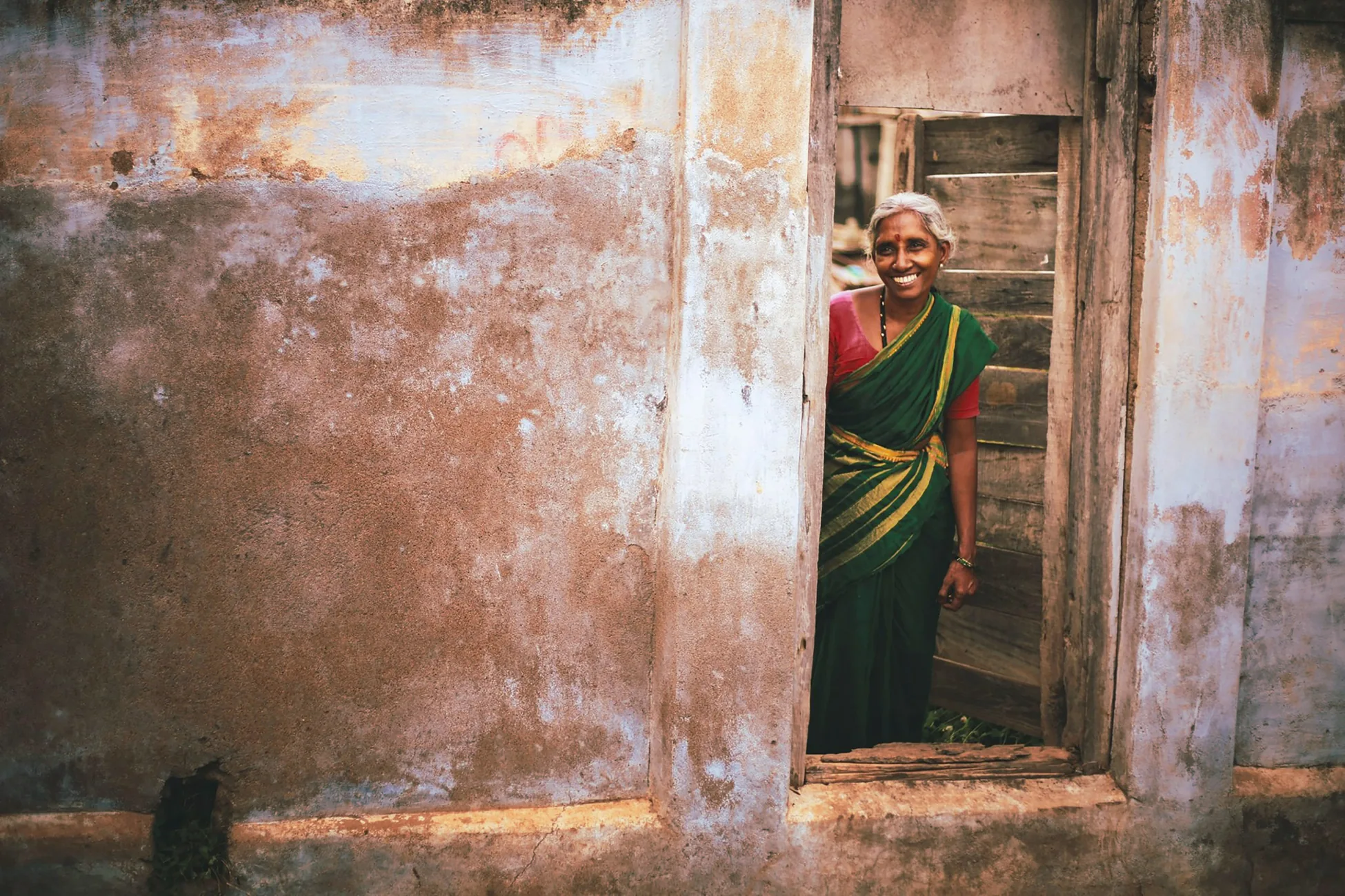 Une habitante souriante sur le pas de sa porte